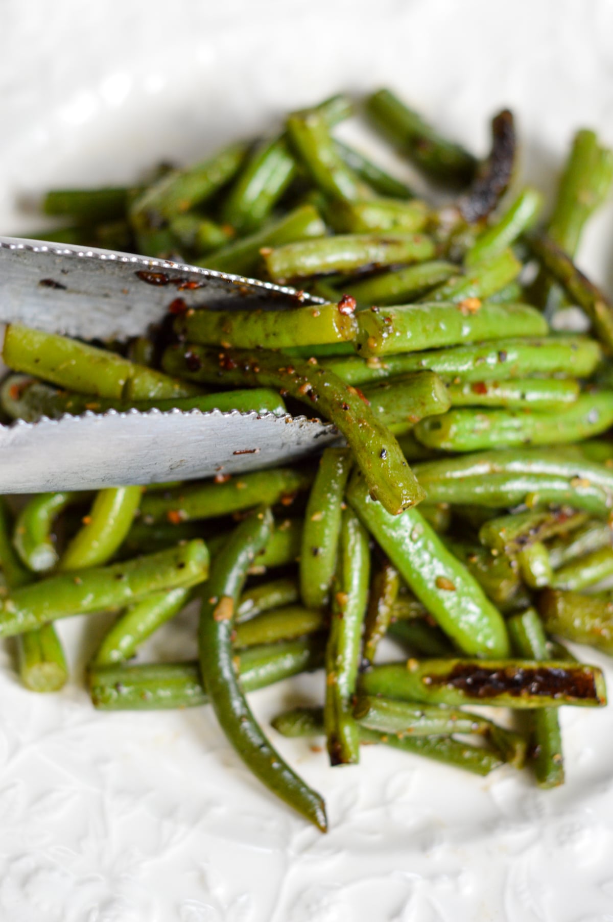 serving garlic green beans with tongs
