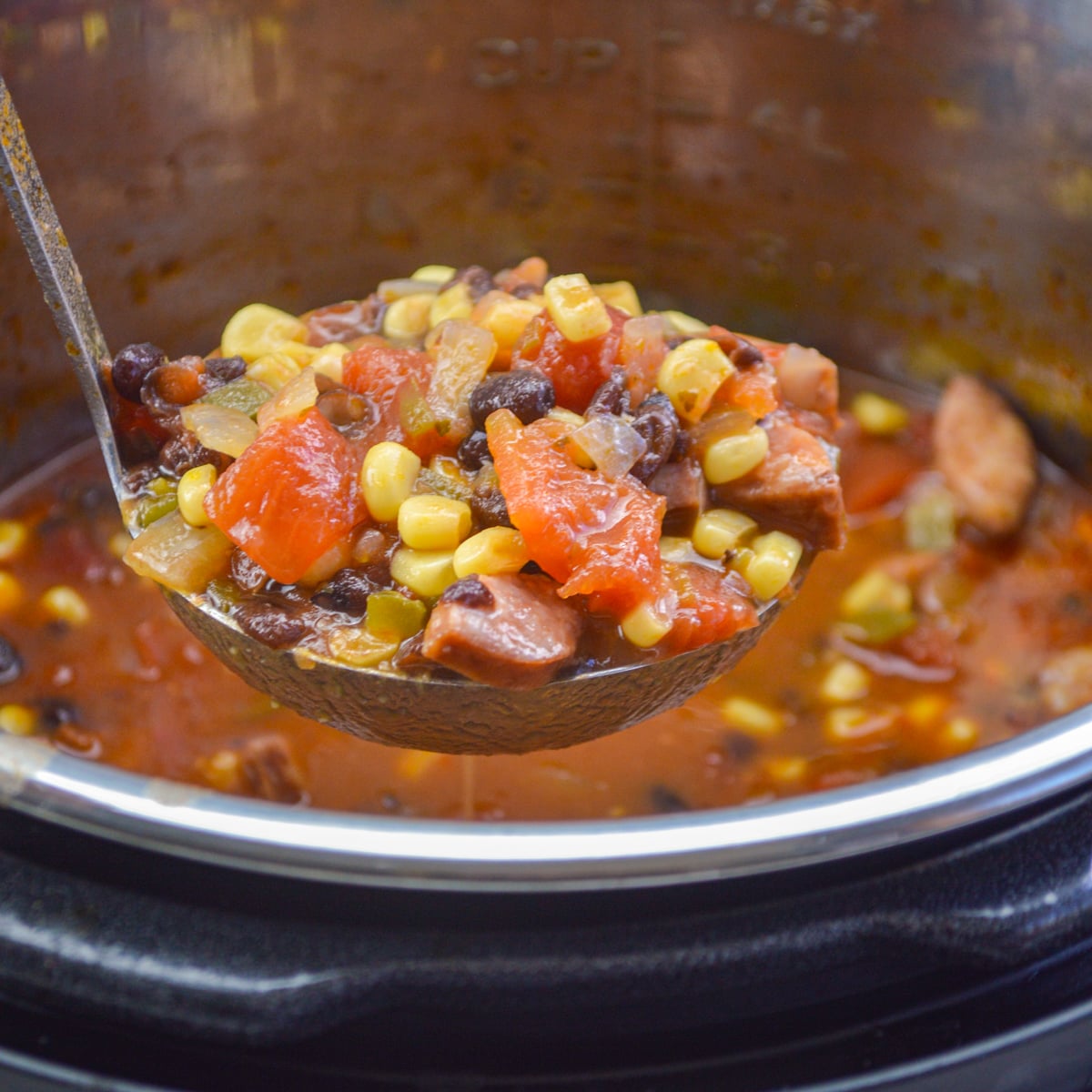 ladle full of black bean soup with sausage