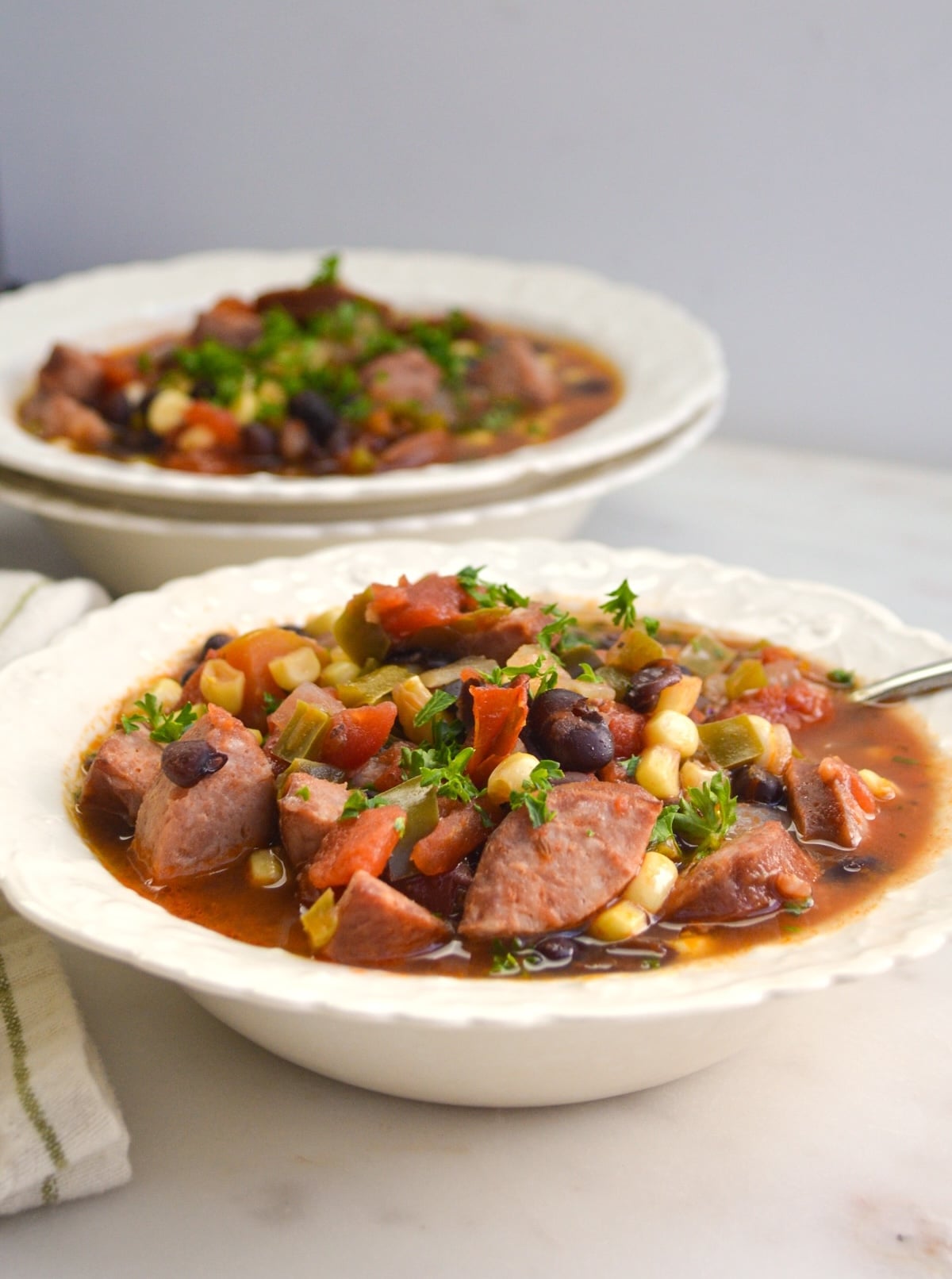 white bowls full of black bean soup with sausage