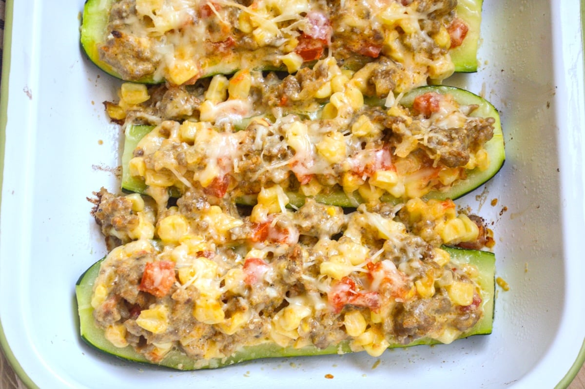 corn-sausage-stuffed zucchini in white pan