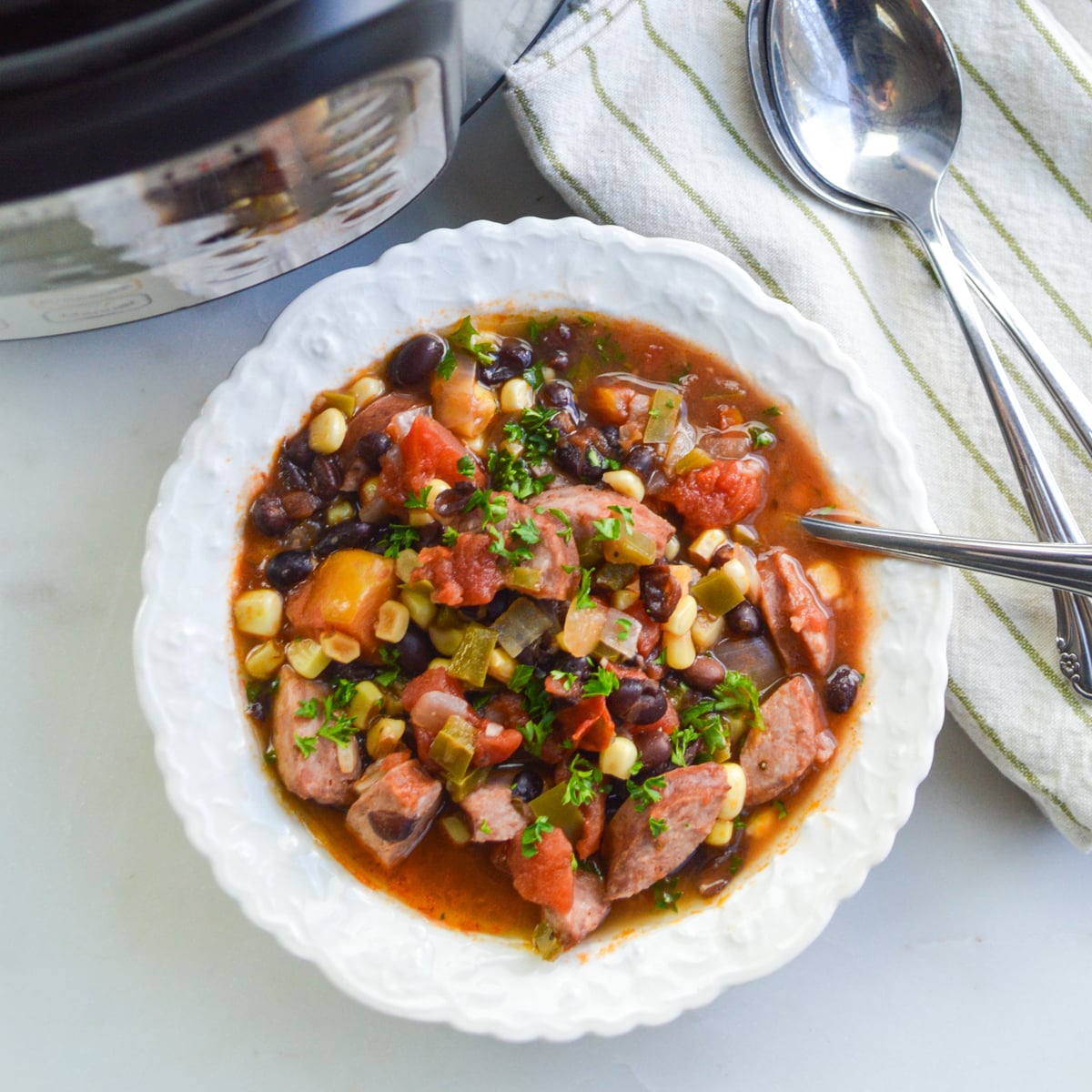 black bean sausage soup in white bowl
