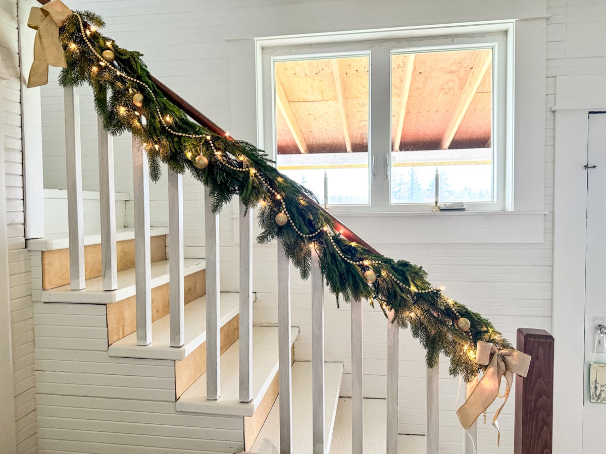 stair rail with garland and lights for Christmas