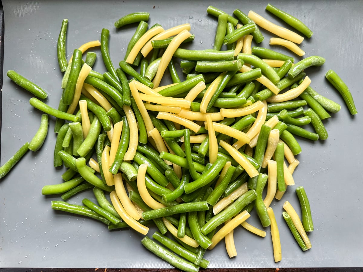 frozen green beans in pile on baking sheet