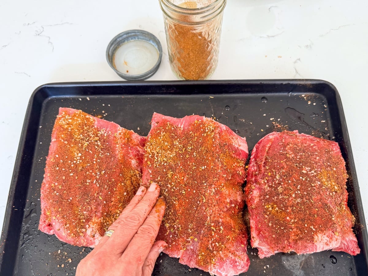 rubbing seasoning on pork ribs