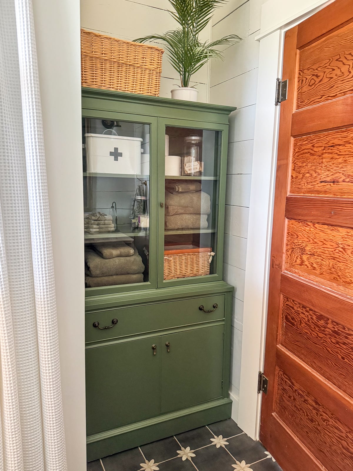 green glass front cabinet in bathroom