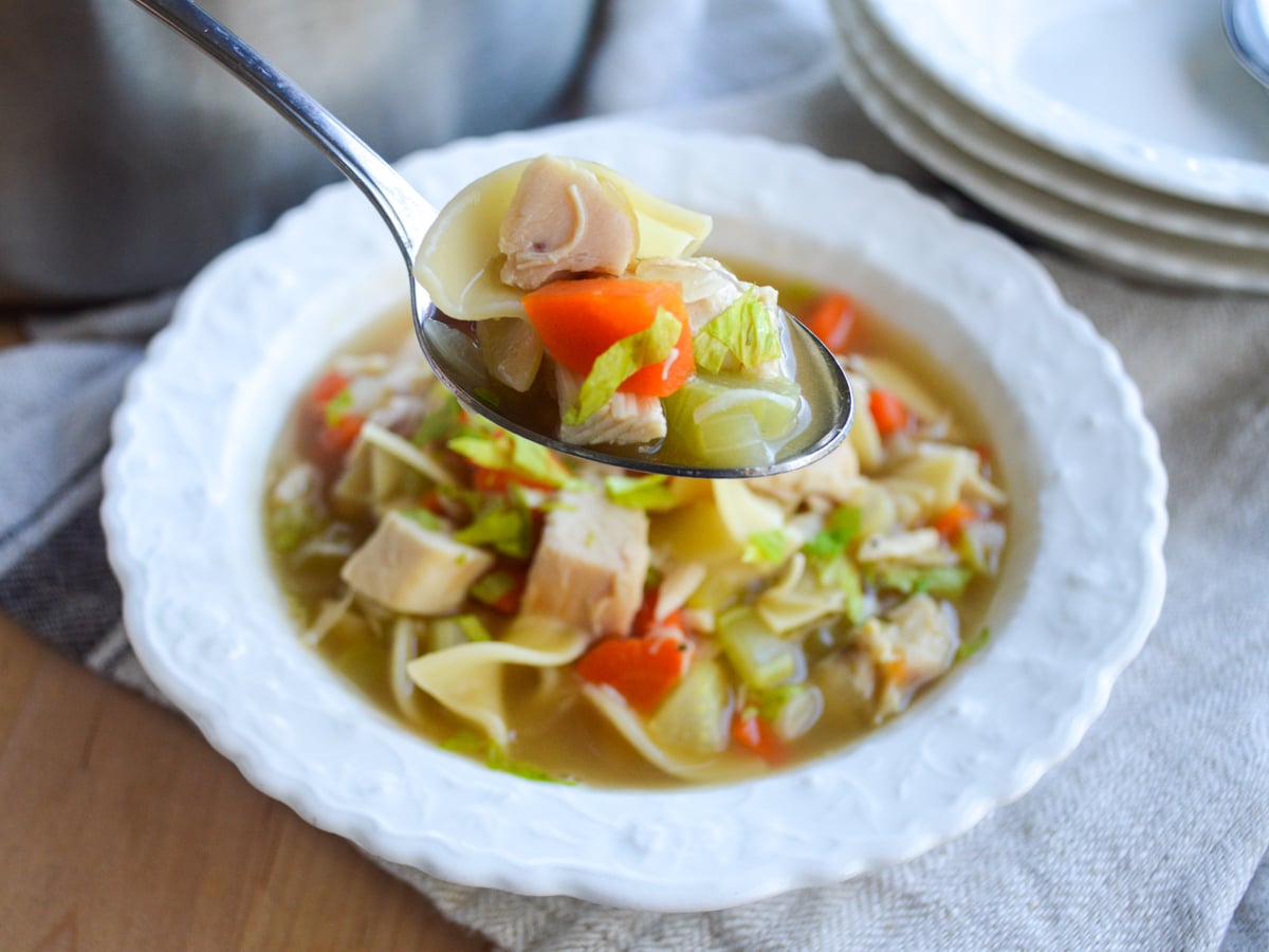 easy chicken noodle soup on spoon in white bowl