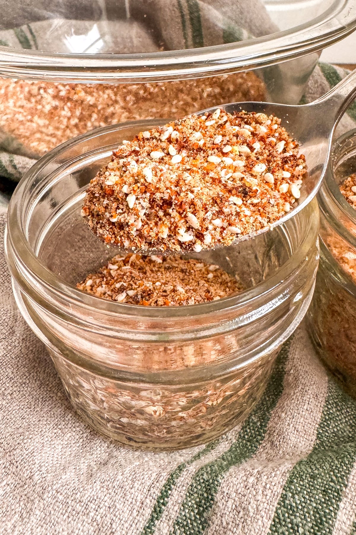 pouring Korean BBQ spice mix into small jar with spoon
