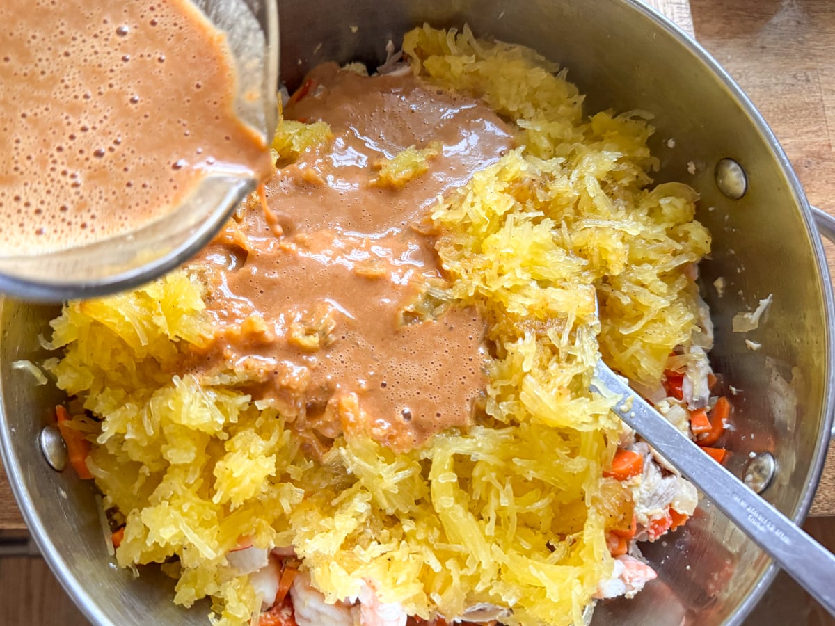 adding peanut sauce to cooked ingredients for spaghetti squash recipe