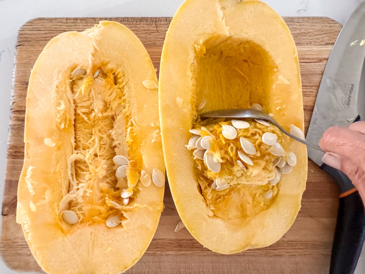 scooping out seeds of spaghetti squash