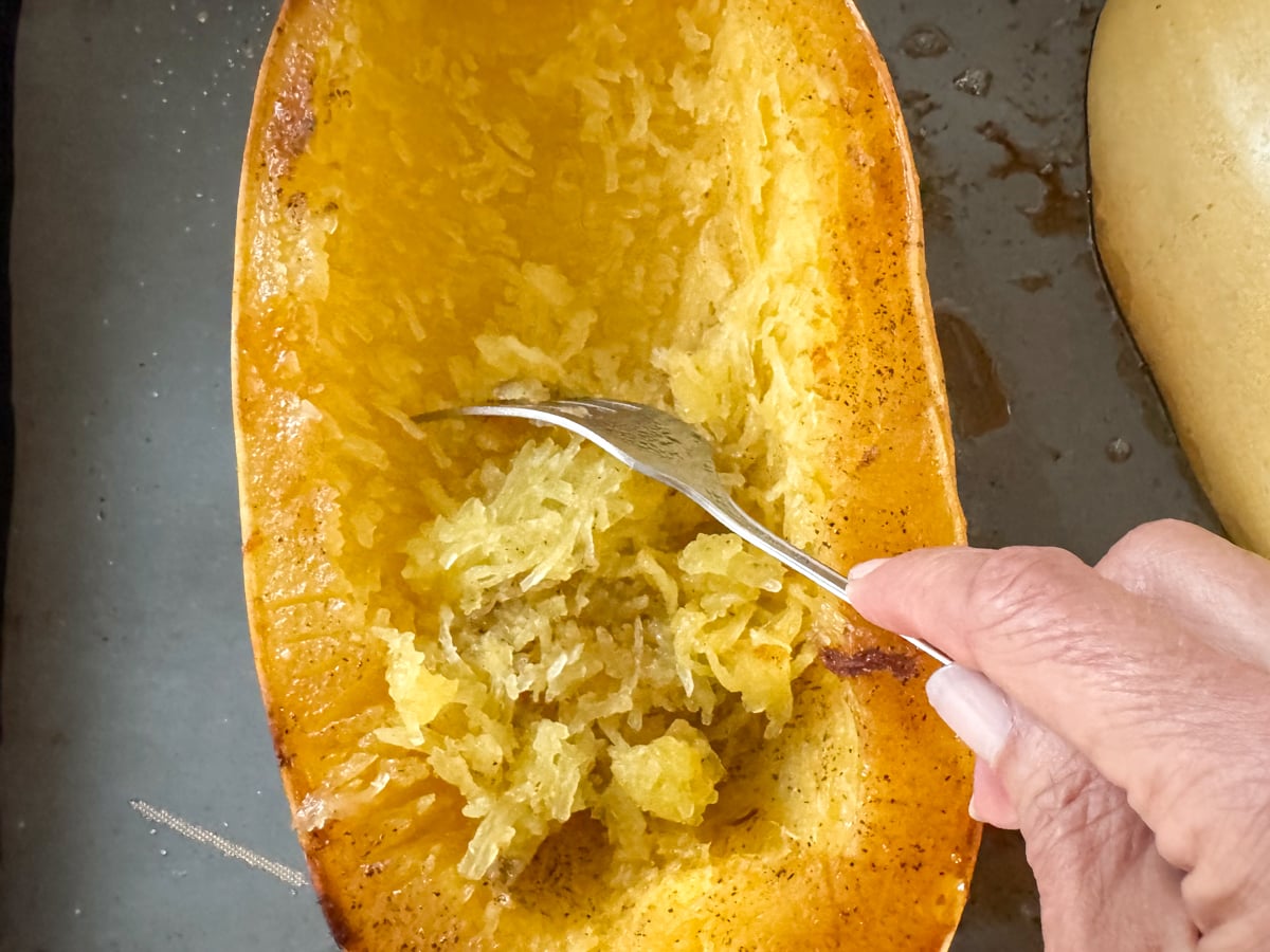 scraping strands of cooked spaghetti squash