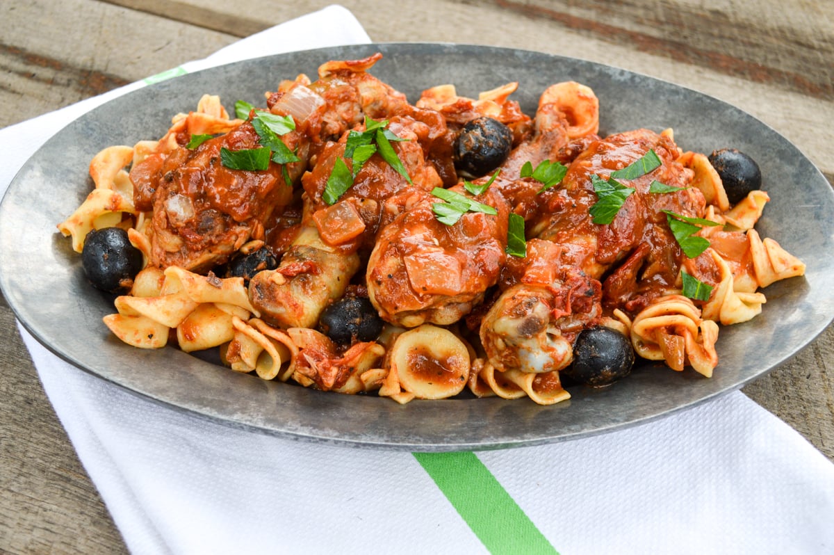 slow cooker chicken with artichokes and olives on pewter plate