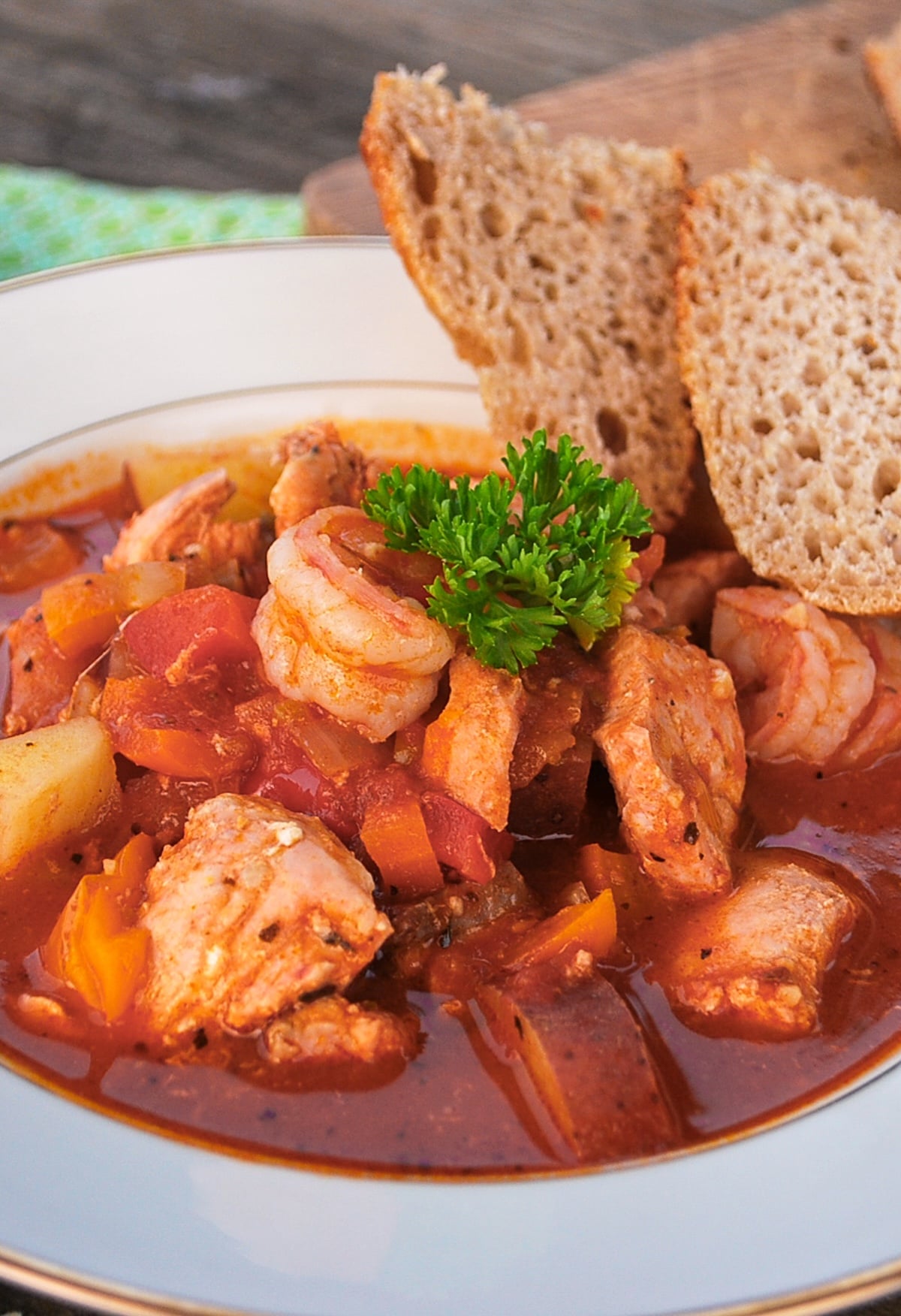 seafood stew in white bowl with bread